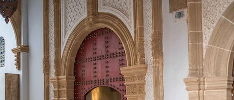 Un arco de piedra con intrincados grabados y una puerta roja.