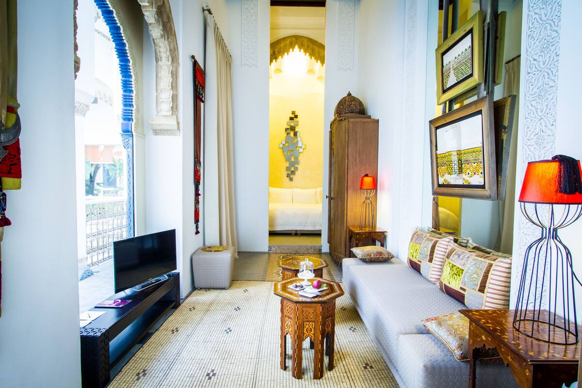 A cozy living room with a sofa, TV, and decorative items.