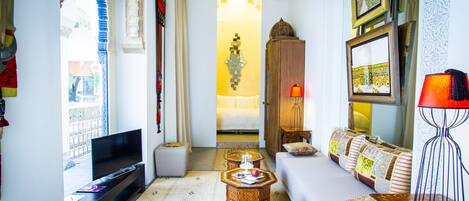 A cozy living room with a sofa, TV, and decorative items.