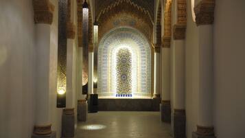 Un couloir orné d’arches décoratives et de motifs complexes incrustés dans les carreaux.