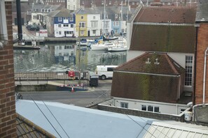 A harbor with boats, a bridge, and buildings in the background. - Boaters Guesthouse (Weymouth)