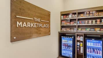 A wooden sign reading "THE MARKETPLACE" above shelves stocked with snacks and beverages, including Pepsi and Coca-Cola.