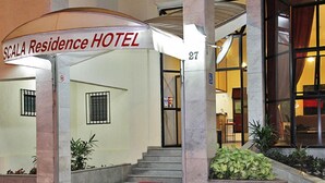 The entrance of Scala Residence Hotel with a sign, a staircase, and a small garden area. - Scala Residence Hotel (Resende)