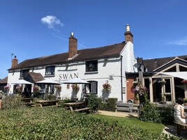 Un pub llamado 'Swan' con terraza y jardín.