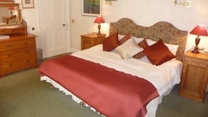 A neatly arranged bedroom with a bed, dresser, and bedside tables, featuring lamps and a mirror. - Spylaw Bank House (Edinburgh)