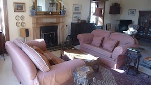 A living room with a fireplace, two sofas, a coffee table, and a patterned rug. - Spylaw Bank House (Edinburgh)
