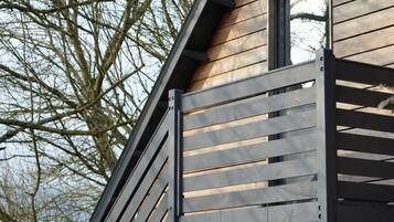 Ein modernes Gebäude mit Holzfassade und einer Metalltreppe, die zu einem Fenster führt.