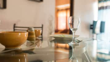 A dining table with a glass wine glass, a bowl, and salt and pepper shakers.
