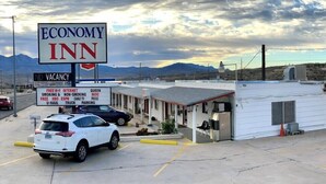 A small, single-story Economy Inn with a signboard advertising amenities like free Wi-Fi, internet, and parking.