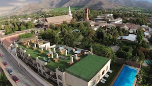 A hotel with a rooftop pool, a church, and mountains in the background. - Terral Hotel & Spa (Vicuña)
