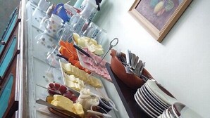 A buffet with various food items and utensils. - Santinho Hostel (Florianópolis)