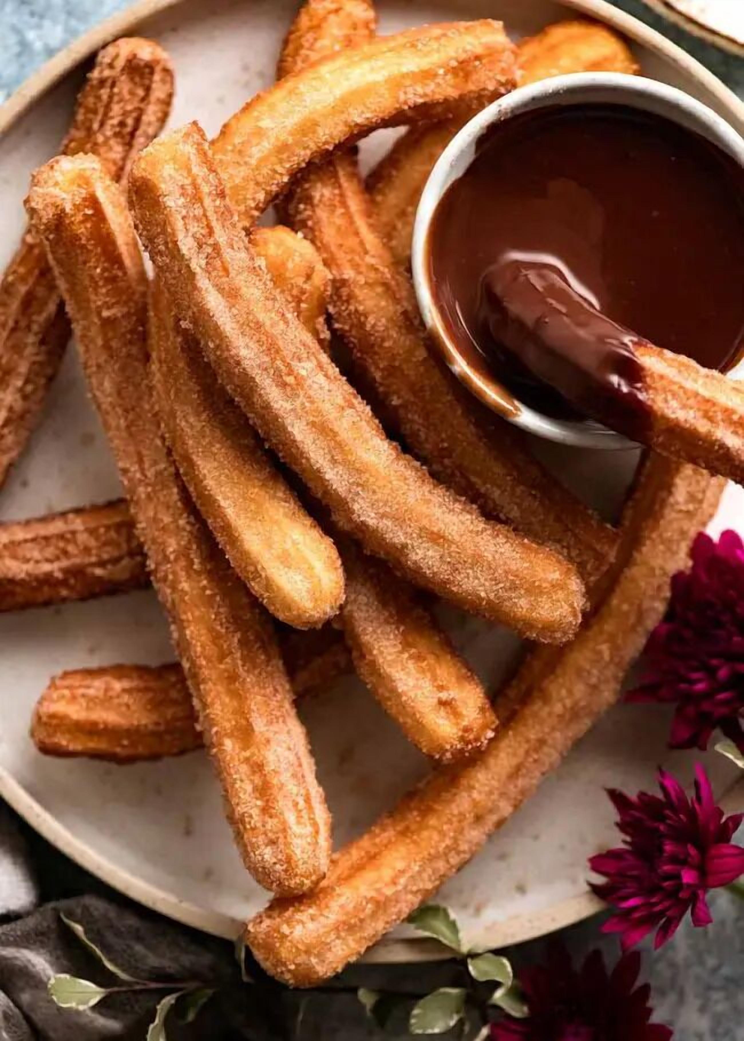 En tallerken med churros og dyppesauce.