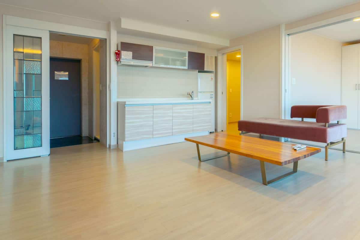Una sala de estar moderna con una mesa de centro de madera, un sofá rojo y un televisor.