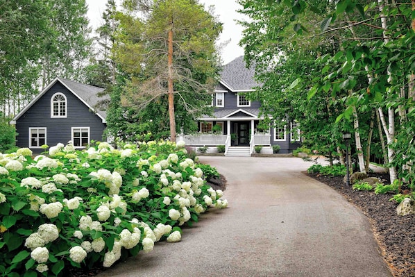 A two-story house with a front porch and a driveway leading to the entrance. - Craigleith Manor Bed & Breakfast (Collingwood)
