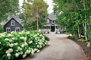 A two-story house with a front porch and a driveway leading to the entrance.