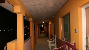 A corridor with benches, a door, and a window. - Budget Inn (Artesia)