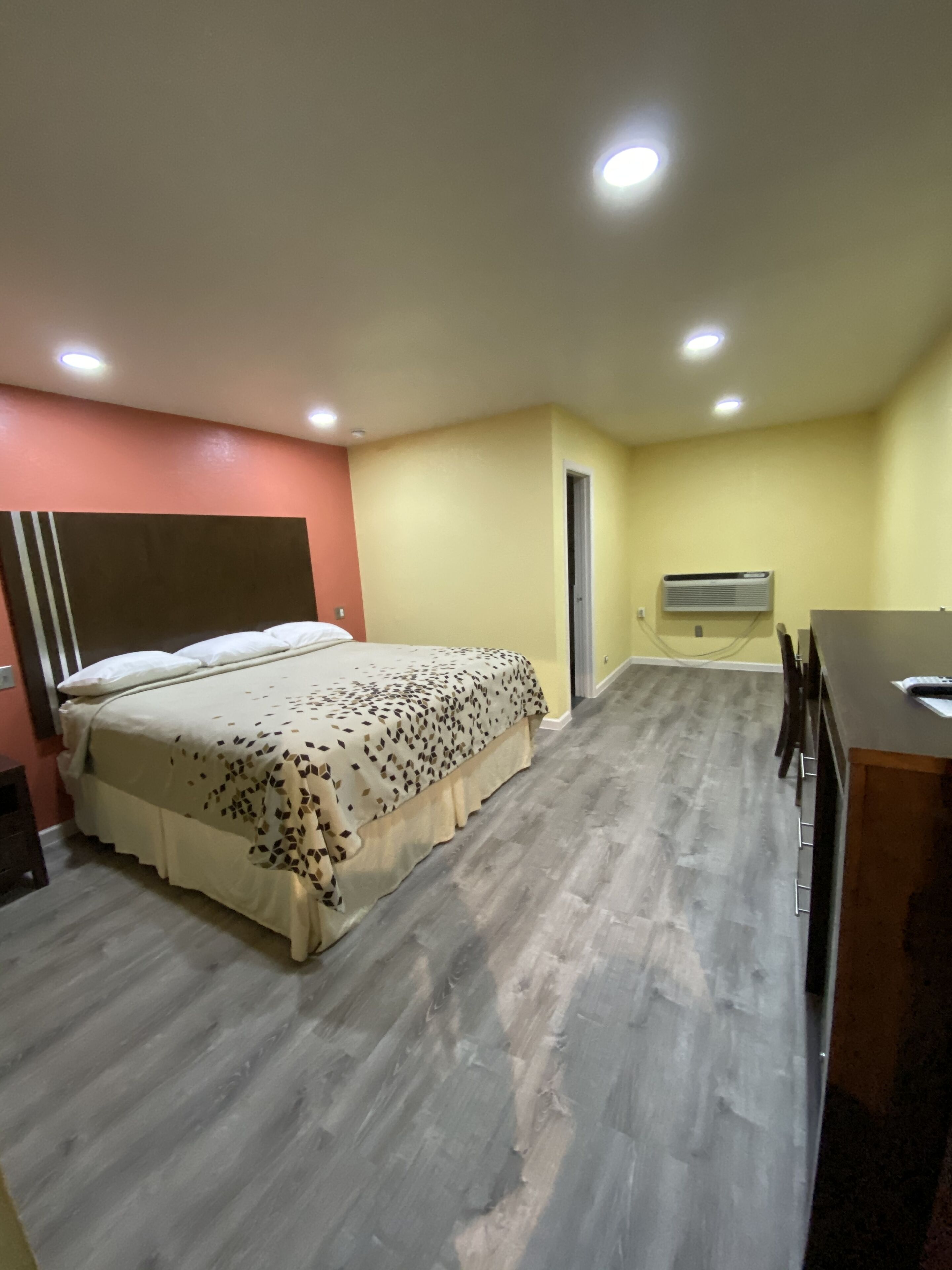 Um quarto com cama, escrivaninha e cadeira.