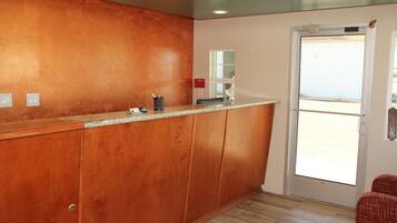 A kitchen with wooden cabinets, a granite countertop, and a door leading to a balcony.
