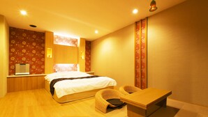 A modern hotel room with a large bed, a wooden desk, and a seating area. - Hotel Atlantis Higashiosaka - Adults Only (Higashi-osaka)
