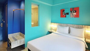 A hotel room with a bed, a nightstand, a bedside table, a mirror, and a door. - Primera Hotel Seminyak (Seminyak)