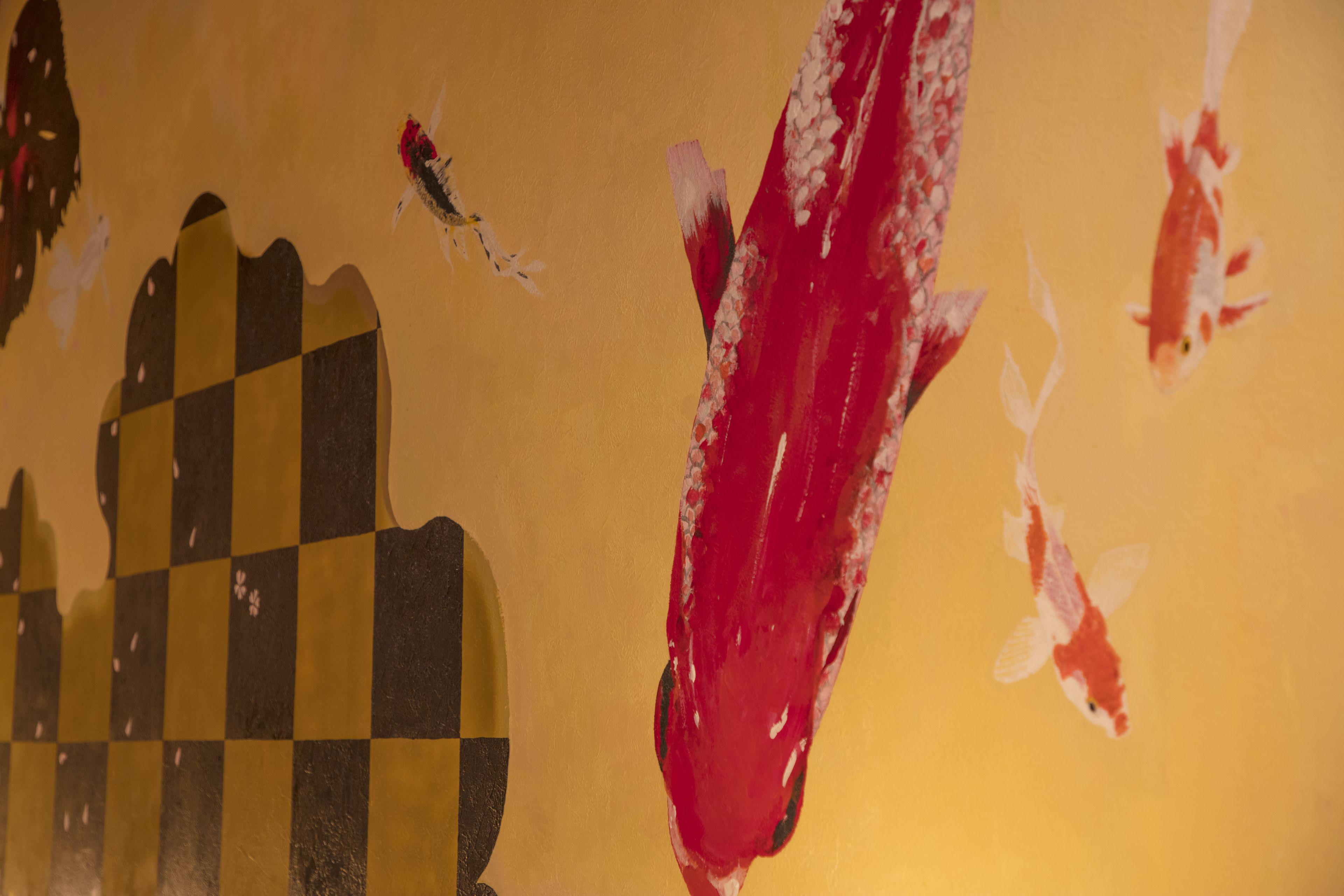 A close-up of a wall with a checkered pattern and a red paint smear.
