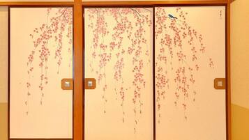 A traditional Japanese room with sliding doors featuring cherry blossom paintings.