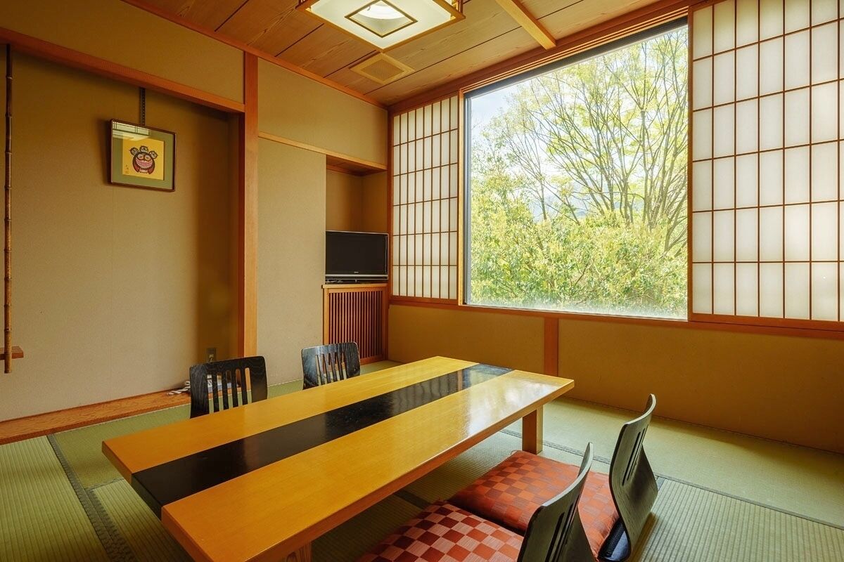 A traditional Japanese room with tatami flooring, a low table, and shoji screens.