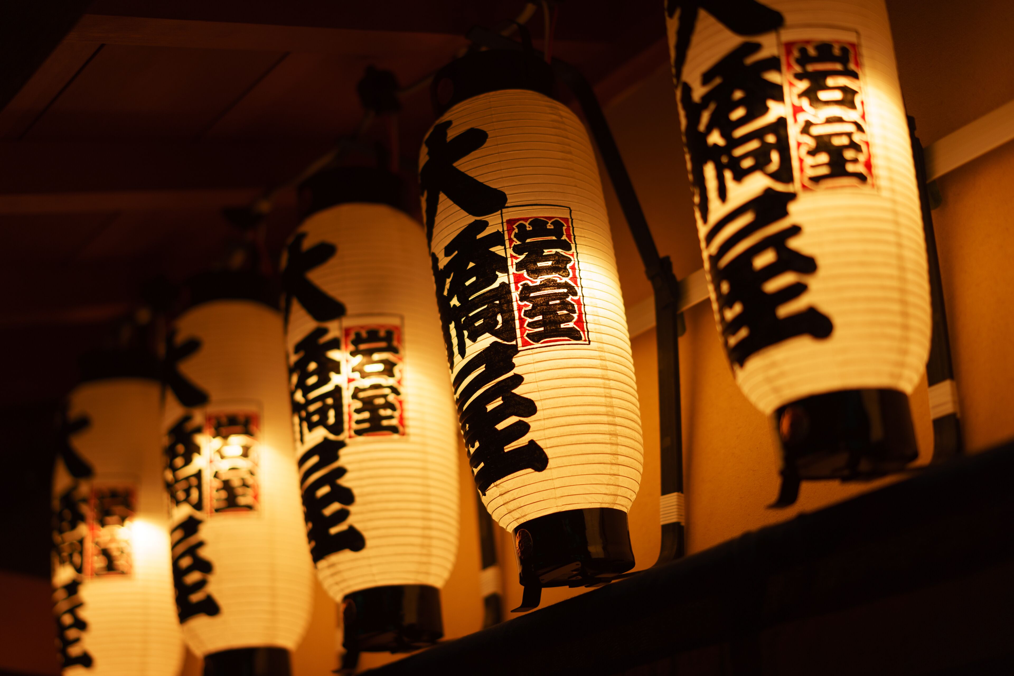 Una hilera de faroles japoneses tradicionales con caligrafía.