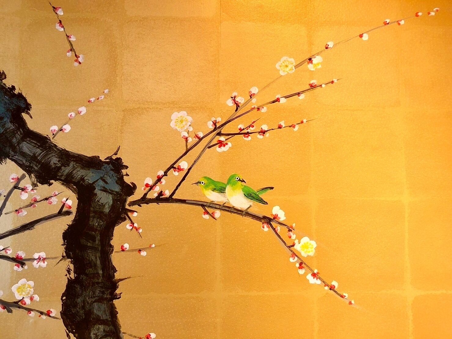 Un pájaro posado en una rama llena de flores.