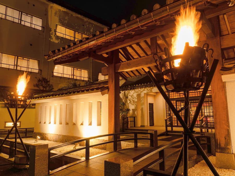 Un patio con pérgola, bancos y una chimenea.