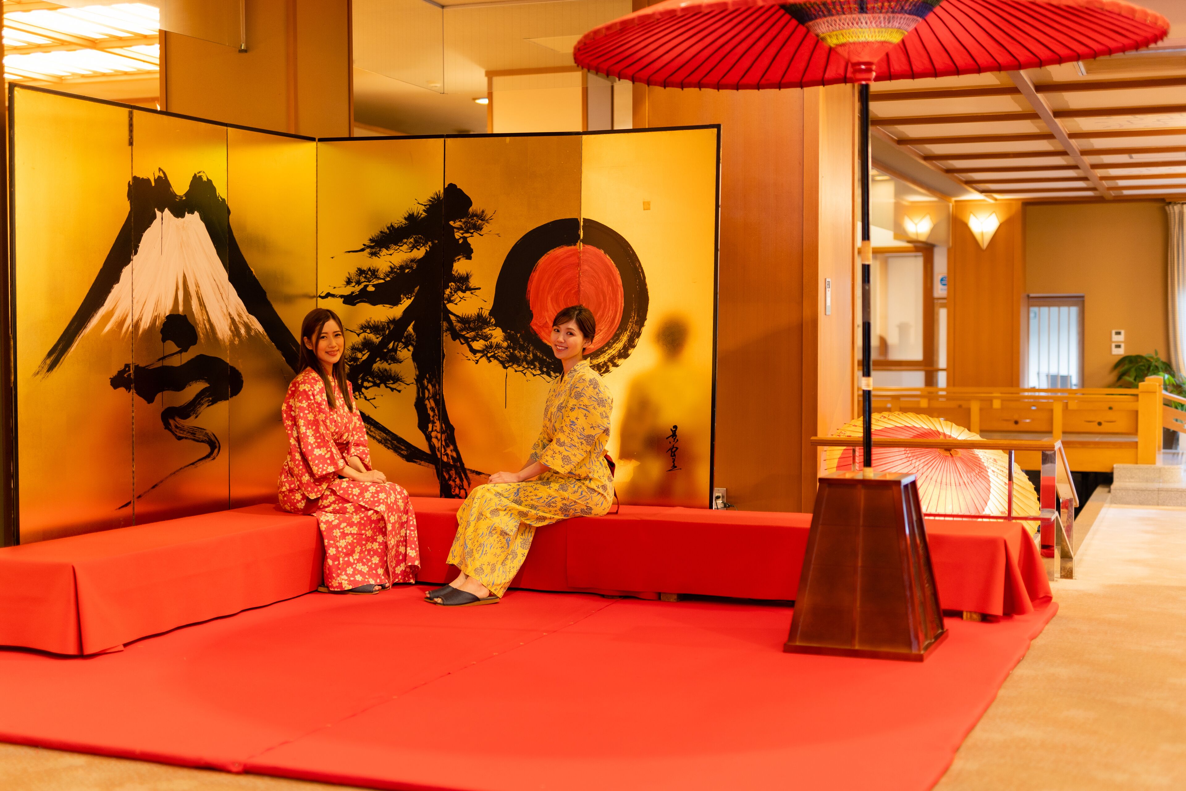 Une pièce de style japonais traditionnel, avec un sol recouvert de tatamis, une table basse et une porte coulissante rouge et jaune.