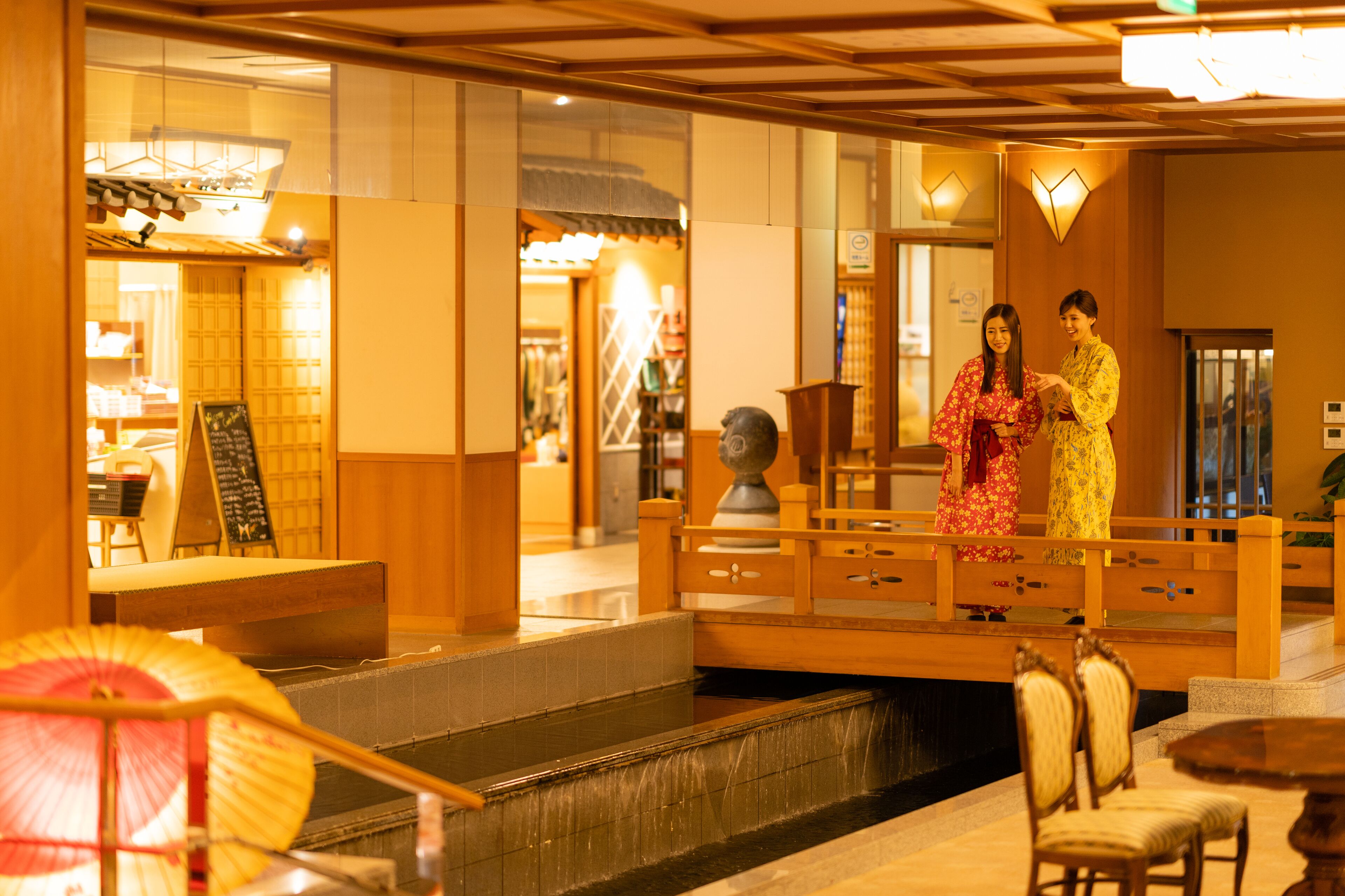 A traditional Japanese interior with a wooden bridge, tatami mats, and a reception area.