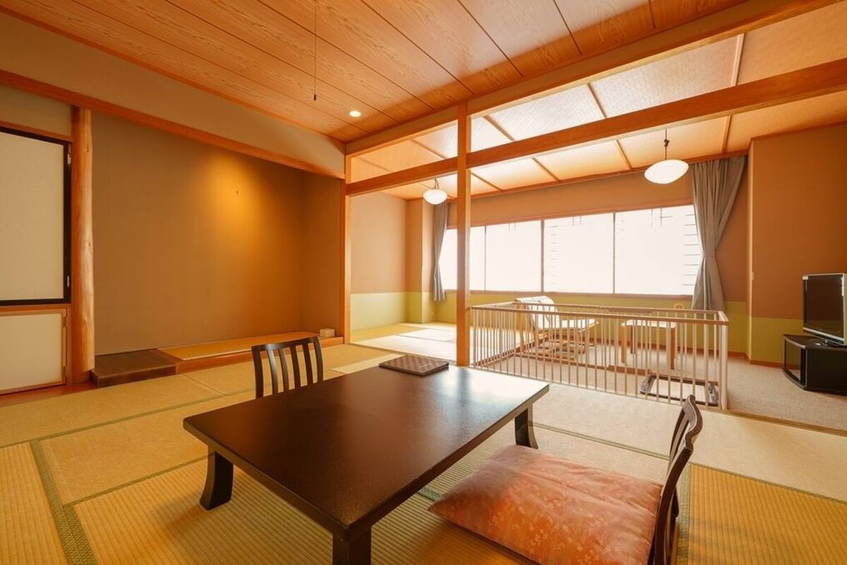 A traditional Japanese room with tatami flooring, a low table, and a view of the outside.