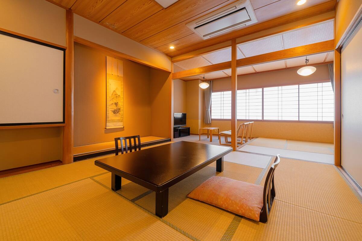 A traditional Japanese room with tatami flooring, a low table, and a sliding door.