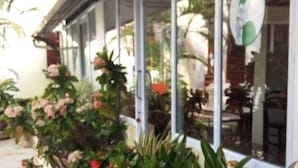 A building with large windows and potted plants along the exterior. - Phonepraseuth Guesthouse (Luang Prabang)