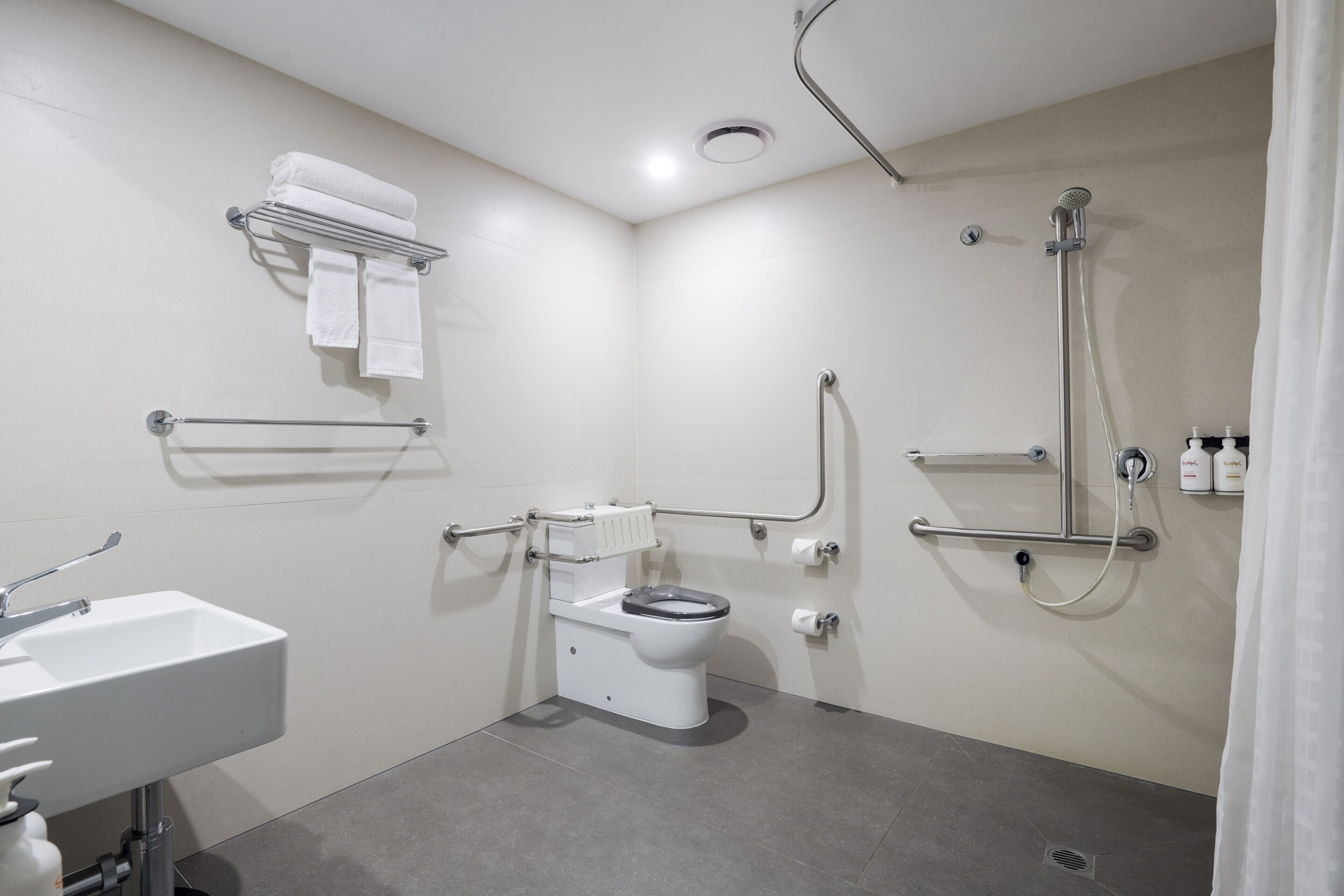 A modern bathroom with a toilet, sink, and shower.