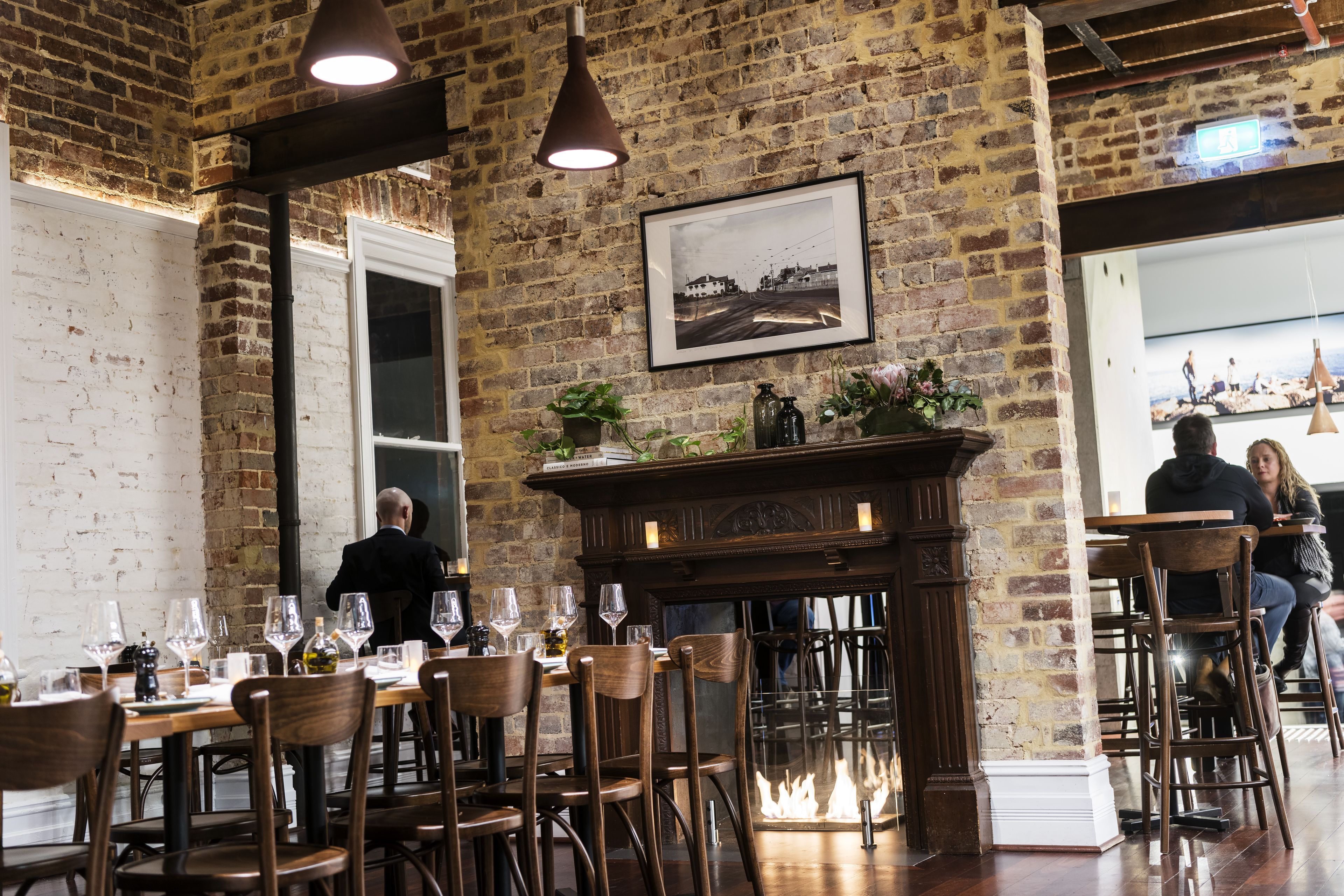 Um restaurante com paredes de tijolo, móveis de madeira e lareira.