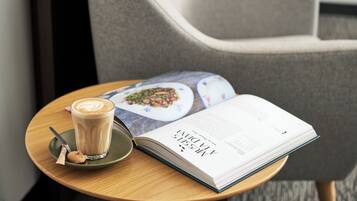 Una mesa con un libro, una taza de café y una galleta.