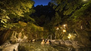 Ein Thermalgebiet mit Felsformationen und einem Holzzaun.