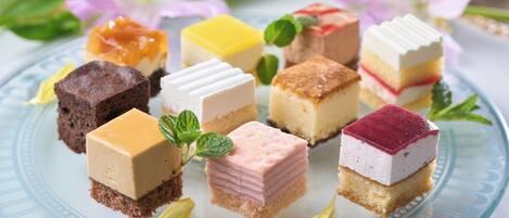 A variety of square desserts on a glass plate.