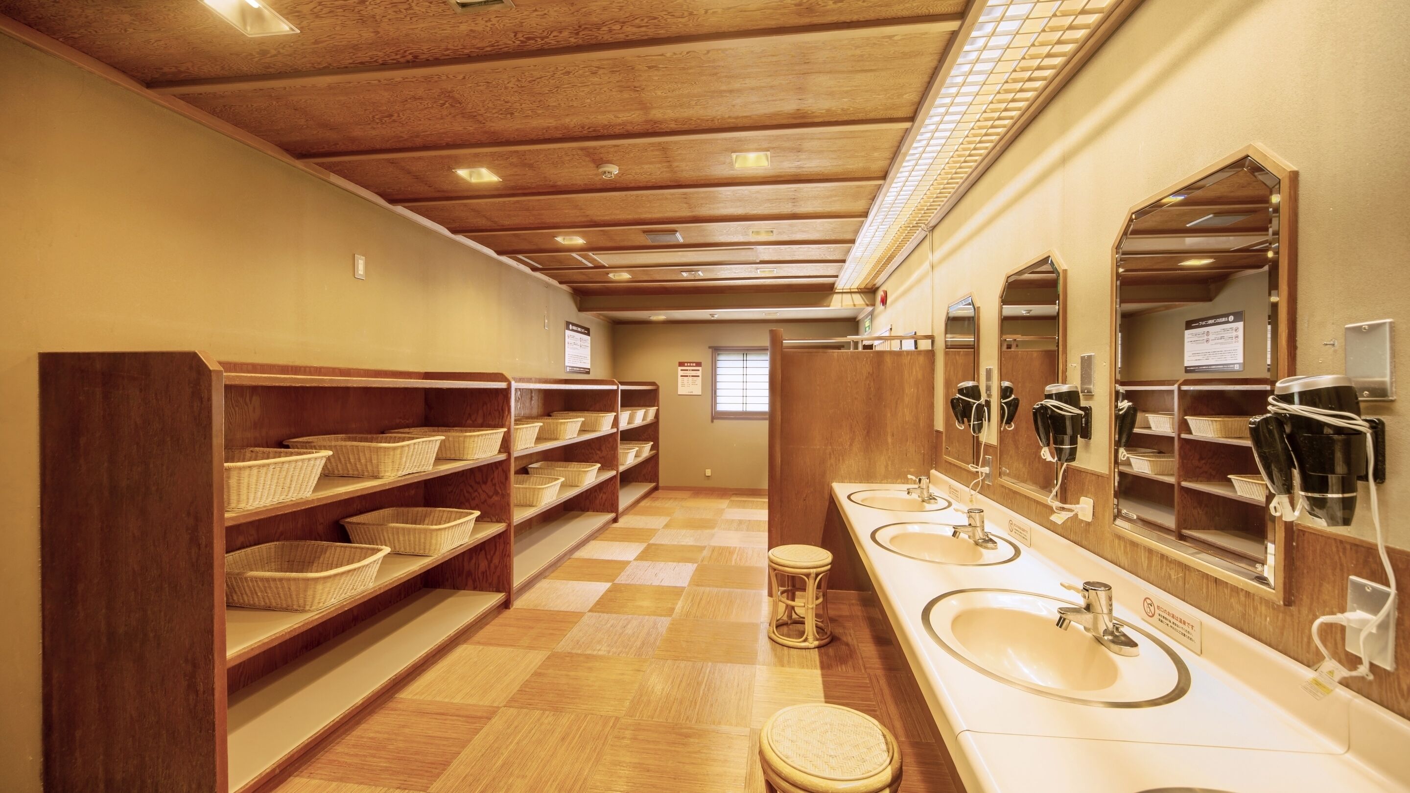 A restroom with wooden shelves, baskets, a checkered floor, and a mirror with a hairdryer.