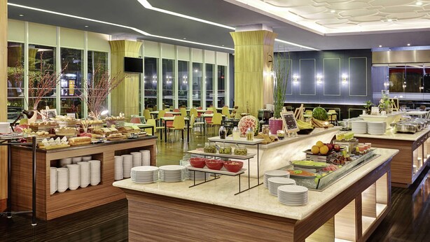 Ein modernes Buffet mit verschiedenen Speisen und einem Sitzbereich mit Tischen und Stühlen.