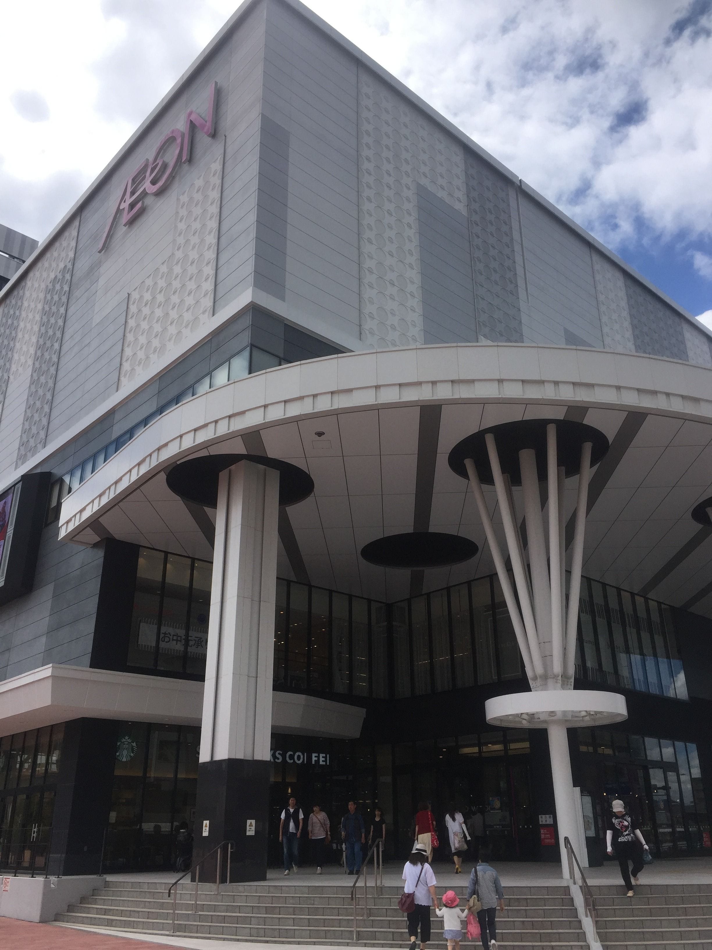 A modern building with a curved entrance and large columns.