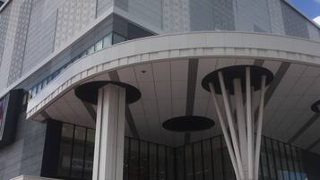 A modern building with a curved entrance and large columns.