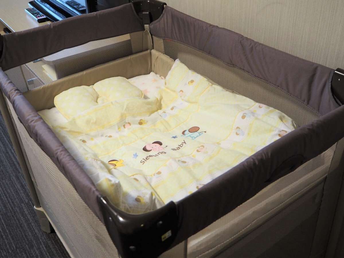 Una cuna convertible con una sábana amarilla para bebé.