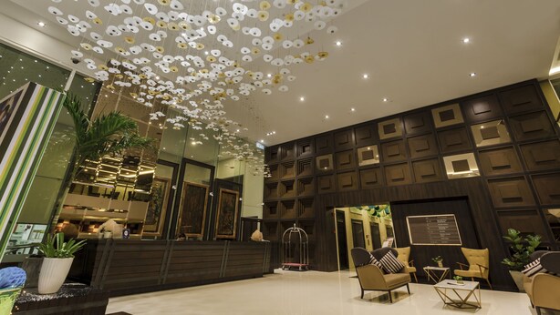 A modern lobby with a unique ceiling design, a reception desk, seating area, and a large mirror. - Verdant Hill Hotel Kuala Lumpur (Kuala Lumpur)