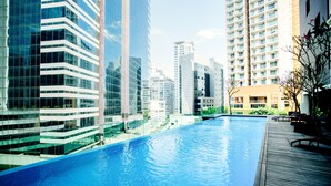 A swimming pool with a wooden deck, surrounded by high-rise buildings. - Verdant Hill Hotel Kuala Lumpur (Kuala Lumpur)