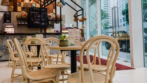 A restaurant interior with wicker chairs, a round table, and a menu board. - Verdant Hill Hotel Kuala Lumpur (Kuala Lumpur)