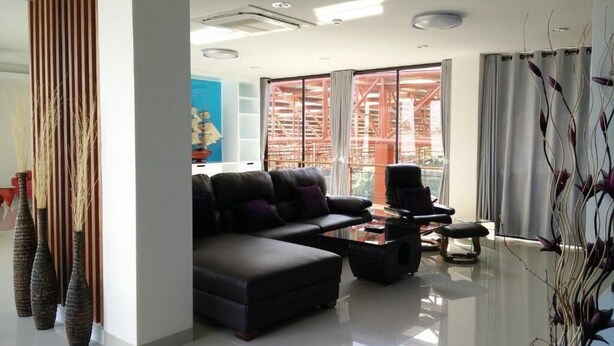Una sala de estar moderna con un sofá, sillones y una mesa de centro.