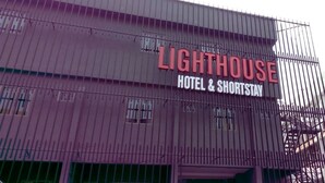 Un edificio con un cartel que dice "LIGHTHOUSE HOTEL & SHORTSTAY".